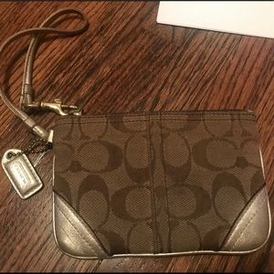 Traditional coach wristlet with gold detail